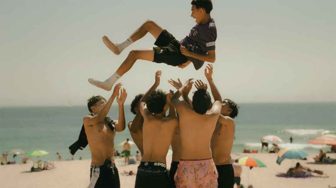 Jogadores a atirar um colega ao ar na praia